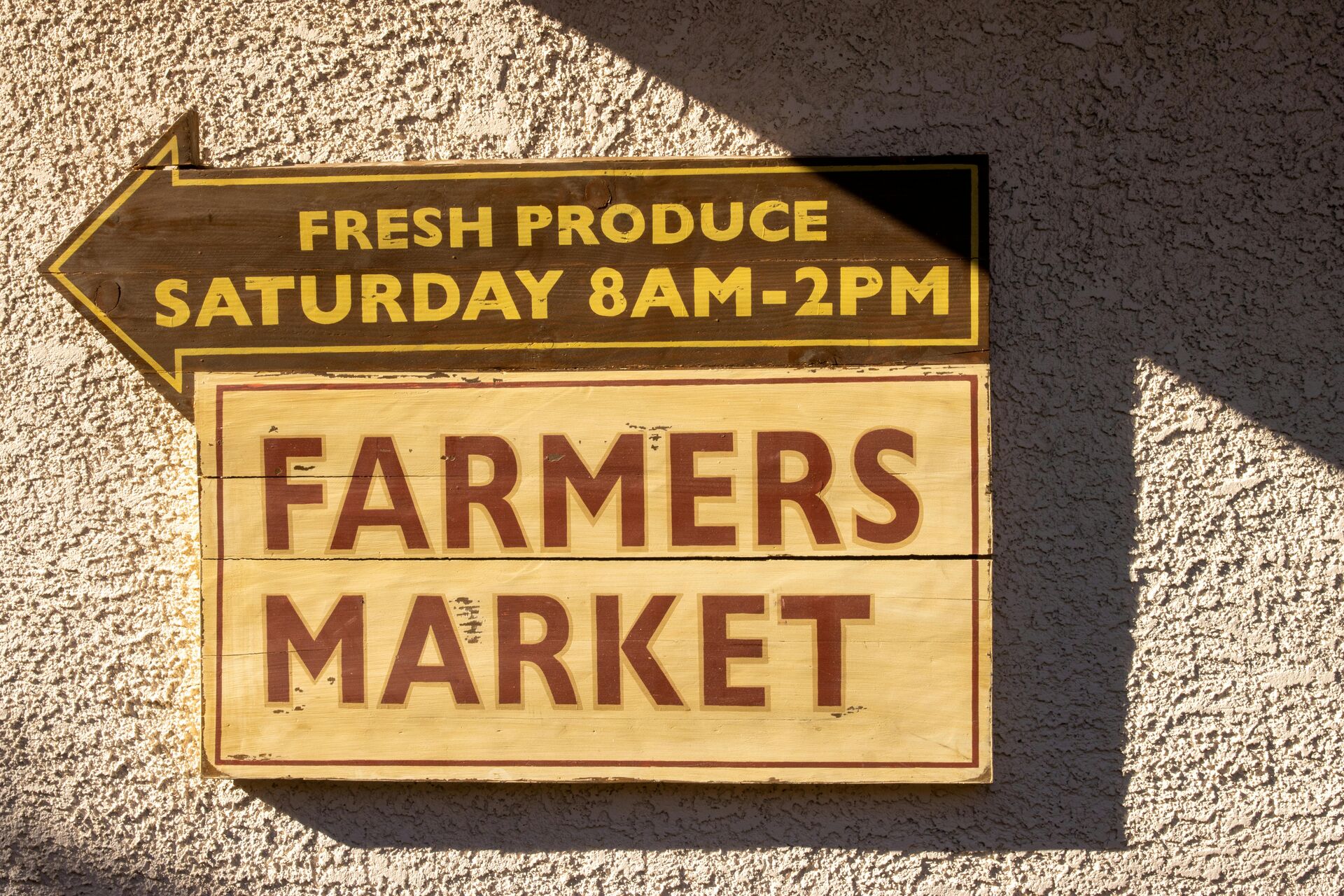 Rustic Farmers Market sign showing fresh produce availability